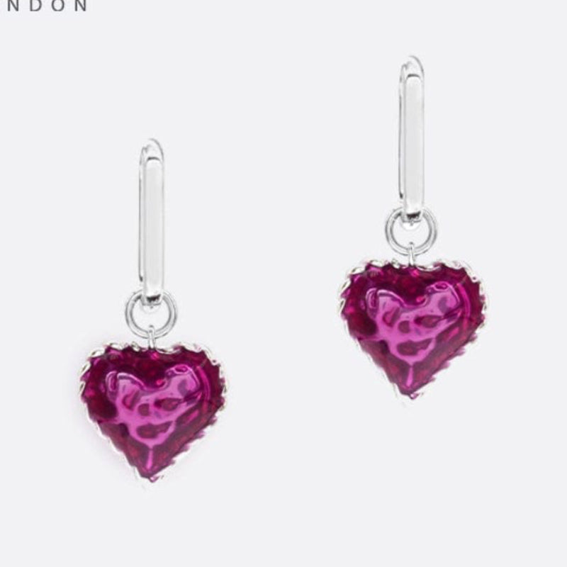 Heart-shaped earrings with pink gemstones on a white background, branded 'SAHI LONDON'.