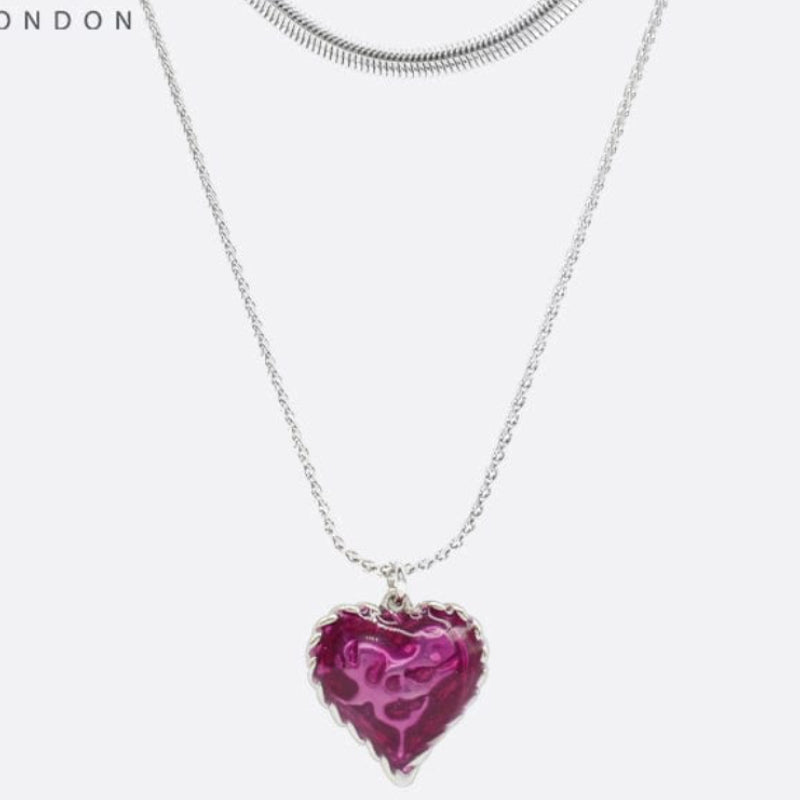 Silver necklace with a pink heart-shaped pendant on a white background, featuring the brand 'SAHI LONDON'.