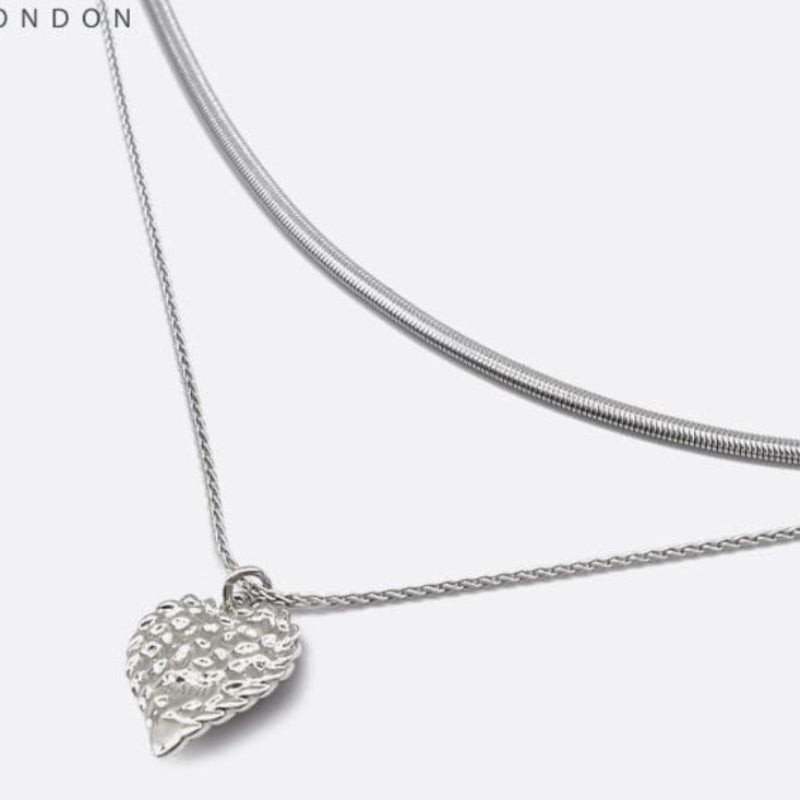 Silver necklace with a leaf pendant on a white background, featuring the brand 'SAHI LONDON'.