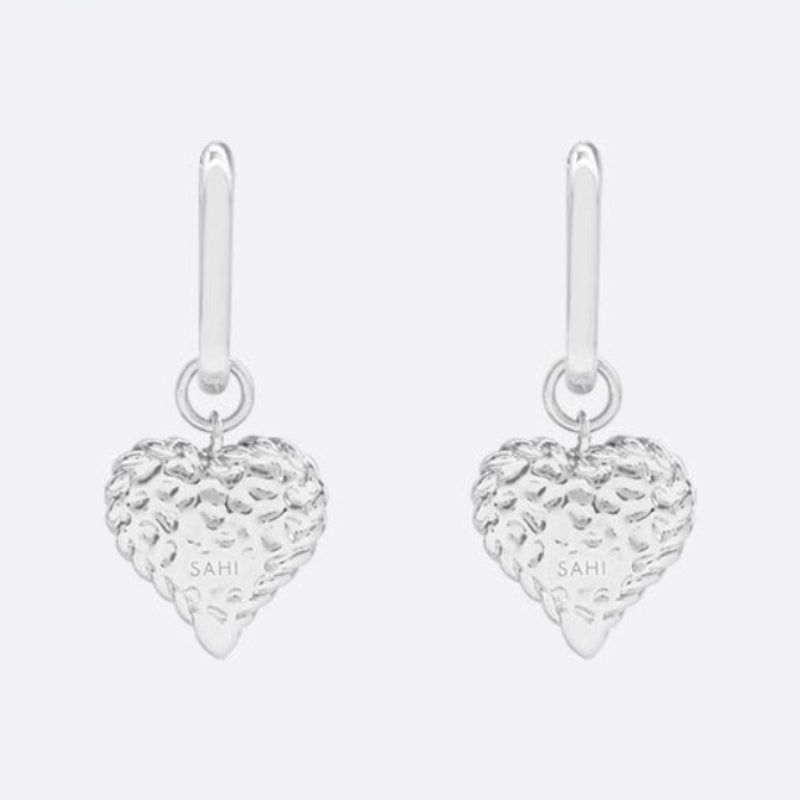 Silver heart-shaped earrings with 'SAHI LONDON' branding on a white background