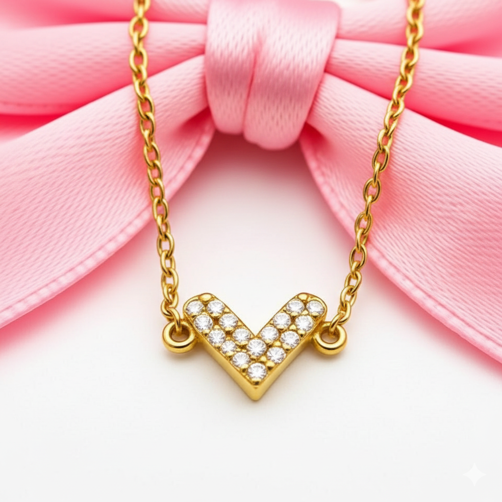 Gold necklace with a heart-shaped pendant on a pink bow background